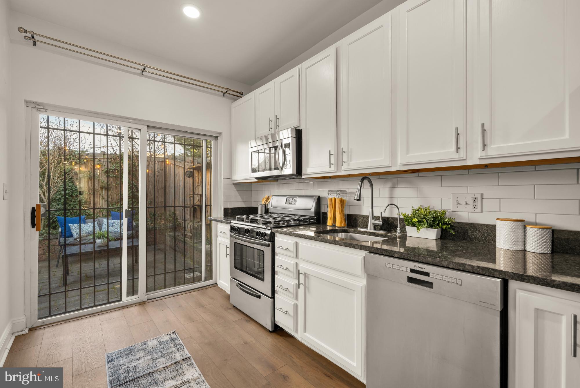706 L Street Southeast Washington, DC 20003 - Photo 8 of 36 a kitchen with stainless steel appliances granite countertop a stove a sink and white cabinets