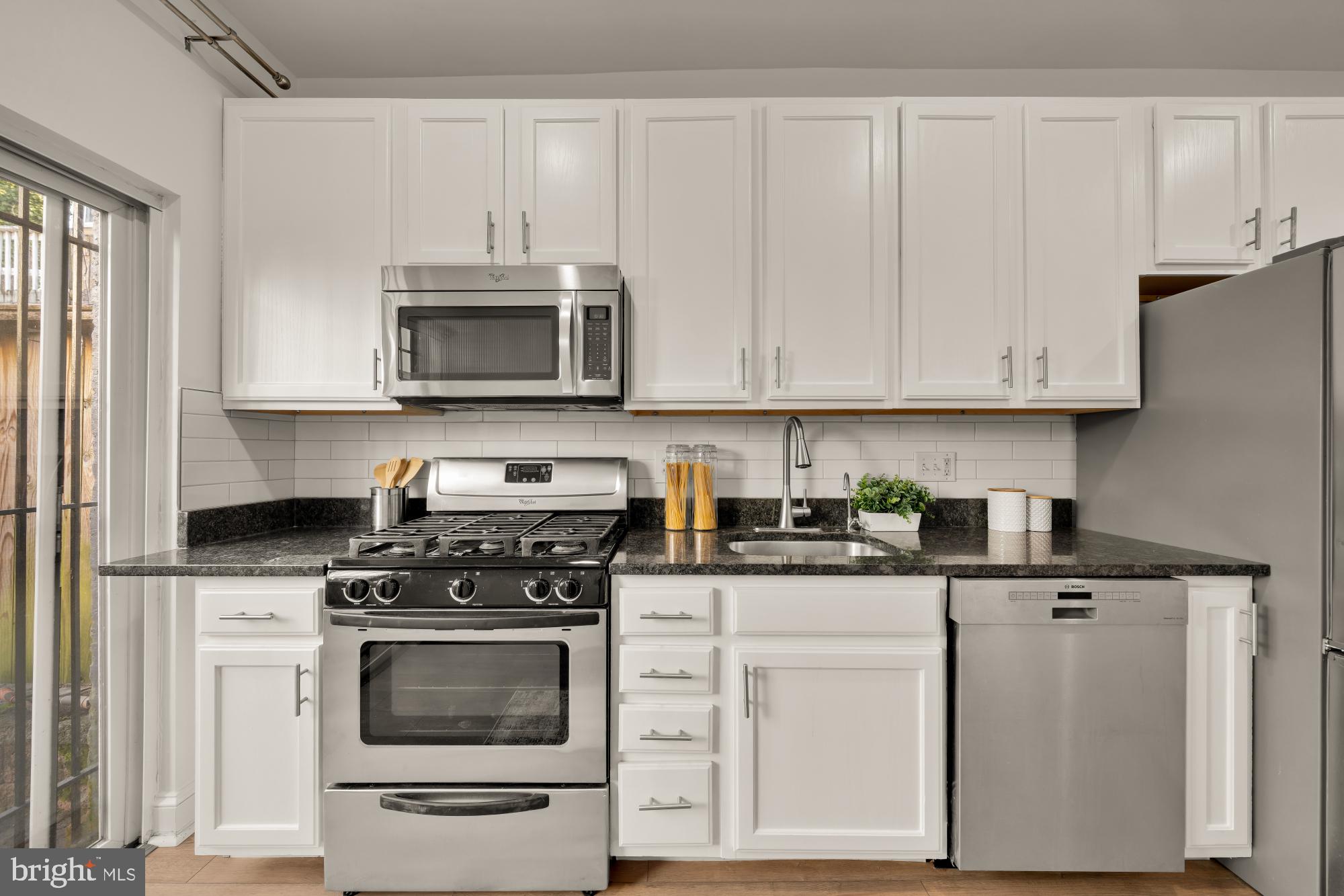 706 L Street Southeast Washington, DC 20003 - Photo 9 of 36 a kitchen with granite countertop white cabinets and stainless steel appliances
