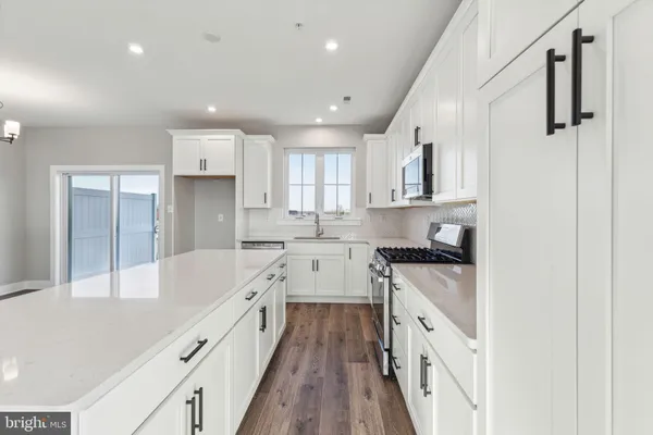 a kitchen with a sink stove top oven and cabinets