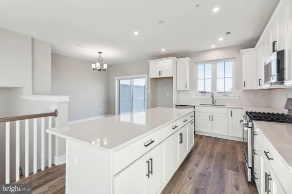 a kitchen with granite countertop a white stove refrigerator and cabinets