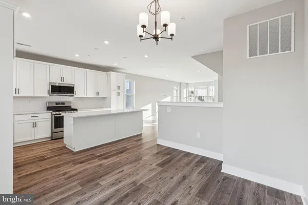 a kitchen with wooden floors and white cabinets