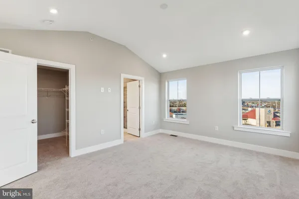 an empty room with windows and closet
