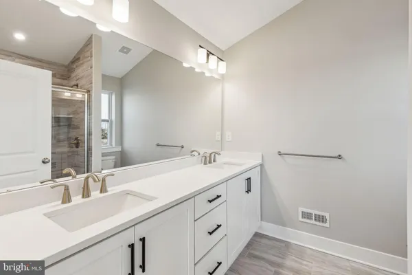 a bathroom with a double vanity sink and mirror