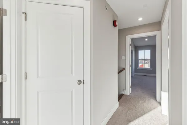 a view of a hallway with wooden floor and closet area