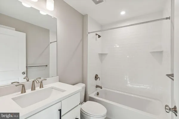a bathroom with a sink toilet vanity and shower