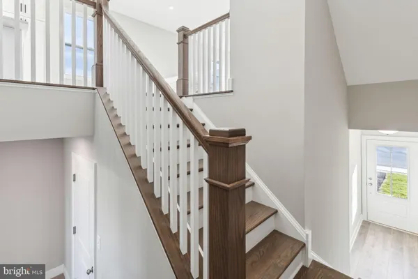 a view of staircase with wooden floor and white walls