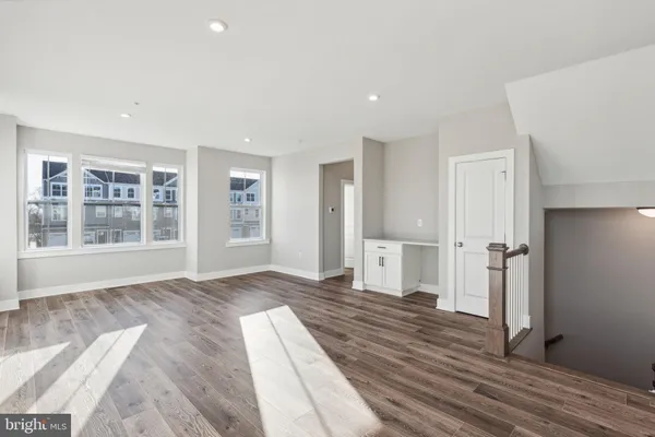 a view of a bedroom with wooden floor and windows