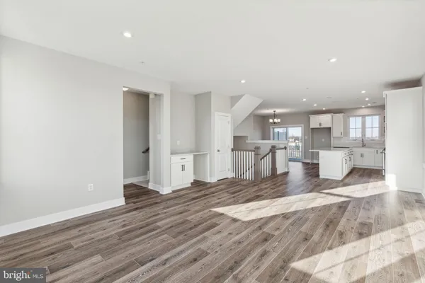 a view of a kitchen with kitchen island a sink wooden floor and a counter top space
