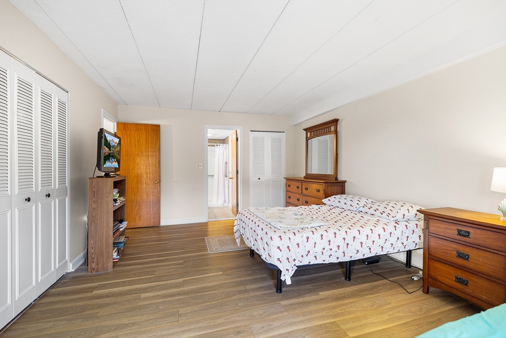 40 Main Street, Unit 505 Stoneham, MA 02180 - Photo 13 of 27 a bedroom with a bed and wooden floor