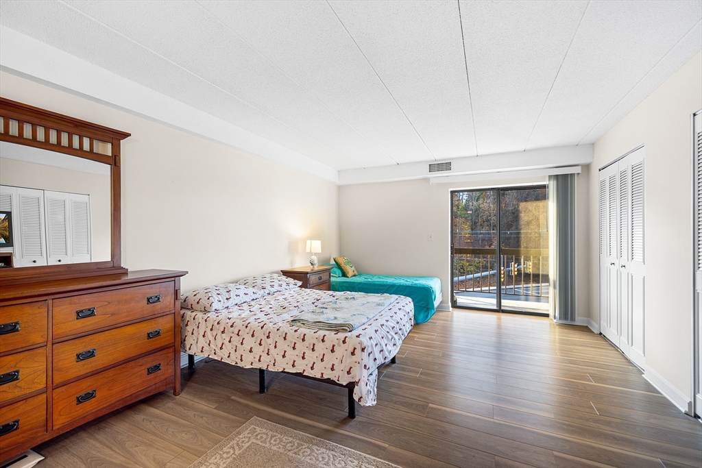 40 Main Street, Unit 505 Stoneham, MA 02180 - Photo 14 of 27 a bedroom with a bed and wooden floor