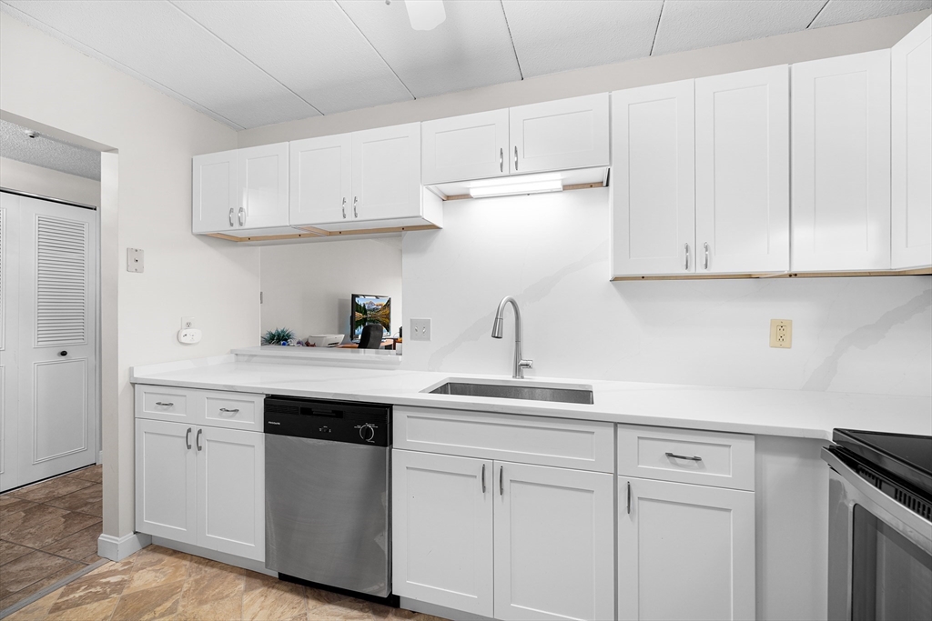 40 Main Street, Unit 505 Stoneham, MA 02180 - Photo 3 of 27 a kitchen with white cabinets and white appliances