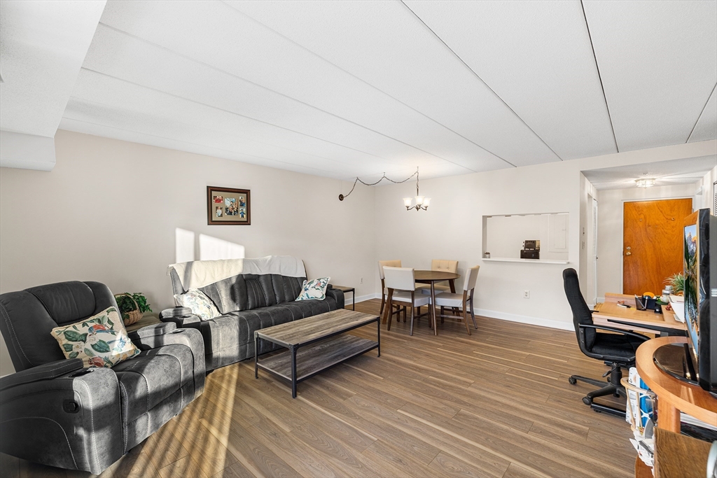 40 Main Street, Unit 505 Stoneham, MA 02180 - Photo 8 of 27 a living room with furniture and a wooden floor