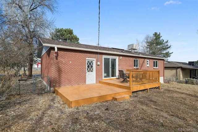 a view of a house with a yard and wooden fence