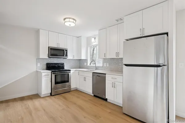 a kitchen with white cabinets and white appliances