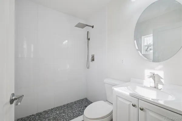 a bathroom with a granite countertop toilet sink and mirror