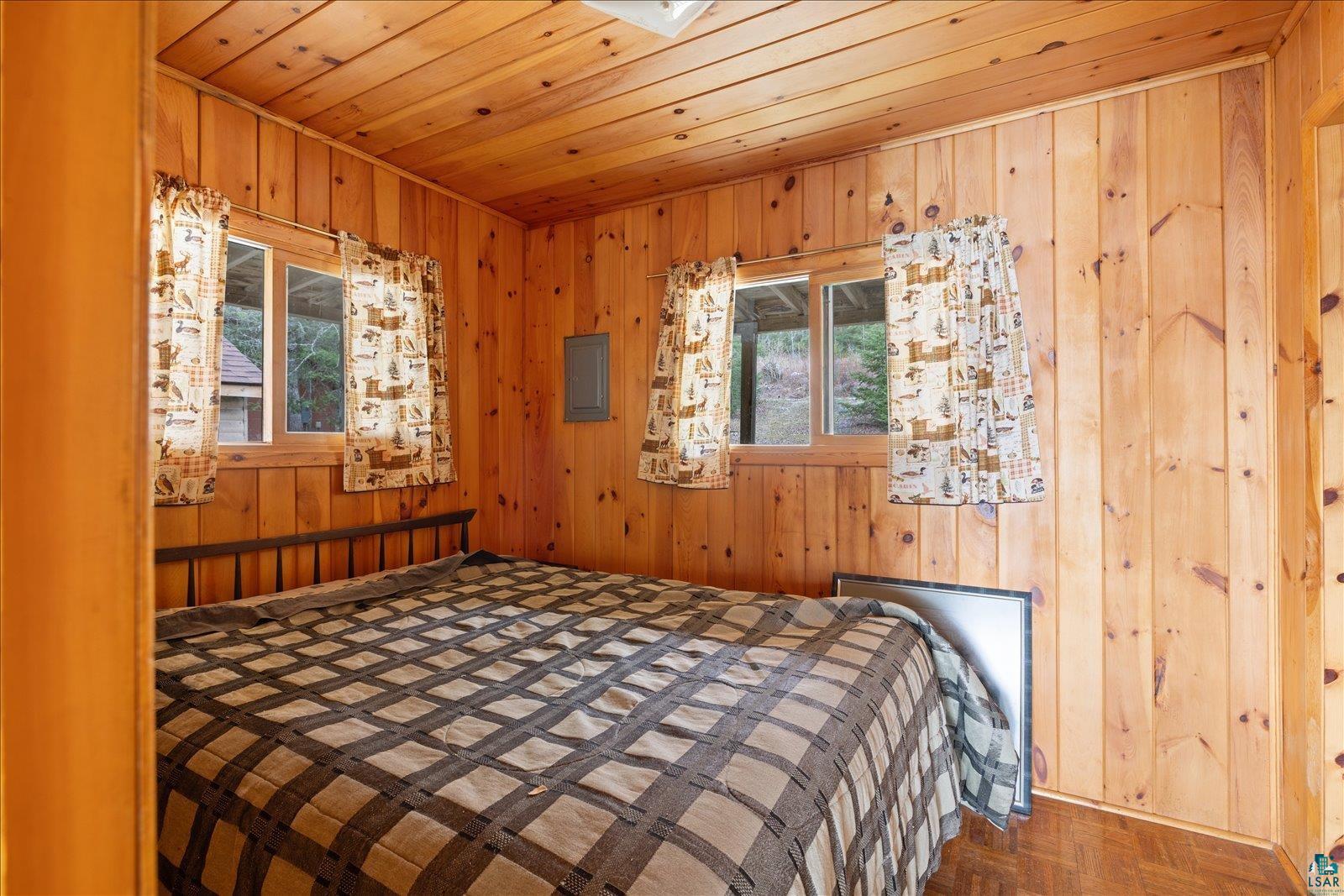 2014 West Frazer Bay Road Cook, MN 55723 - Photo 12 of 26 Wood-paneled room featuring wood-finish flooring and two windows with natural light