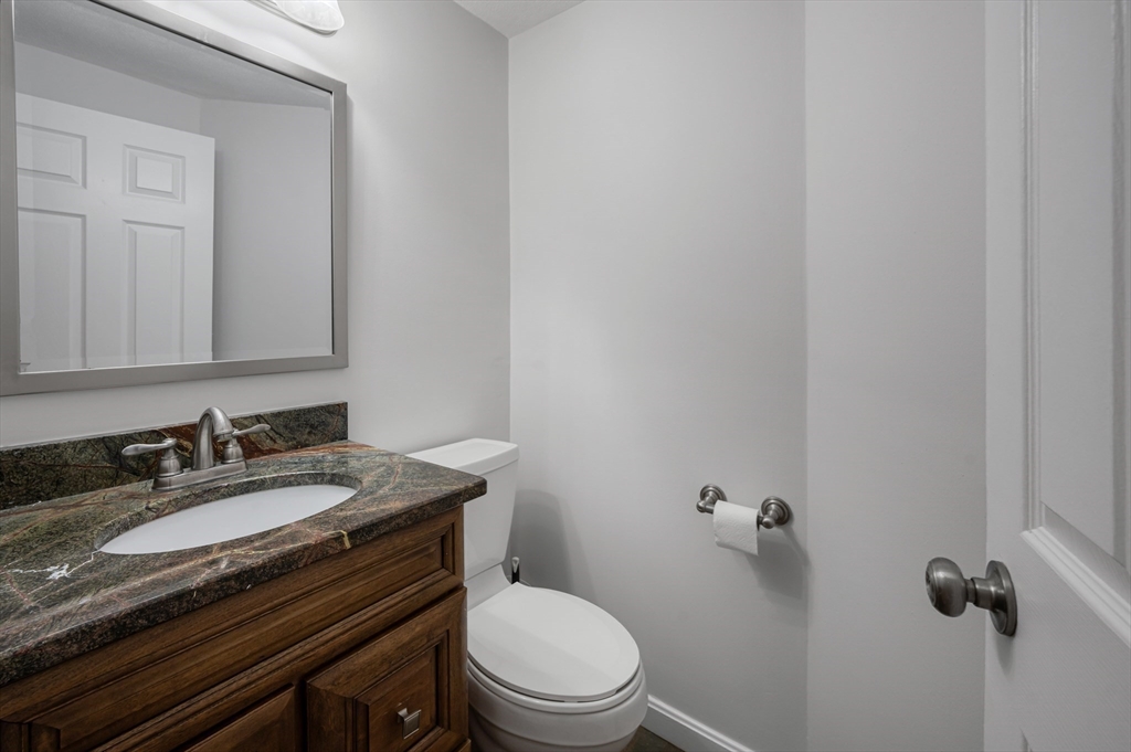 4 Deer Path, Unit 3 Maynard, MA 01754 - Photo 11 of 27 a bathroom with a granite countertop toilet sink and mirror