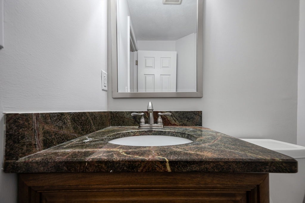 4 Deer Path, Unit 3 Maynard, MA 01754 - Photo 12 of 27 a bathroom with a granite countertop sink and a mirror