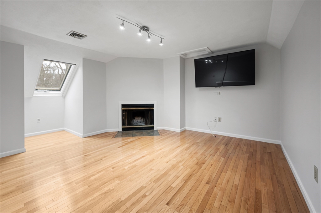 4 Deer Path, Unit 3 Maynard, MA 01754 - Photo 22 of 27 a view of empty room with wooden floor and fireplace