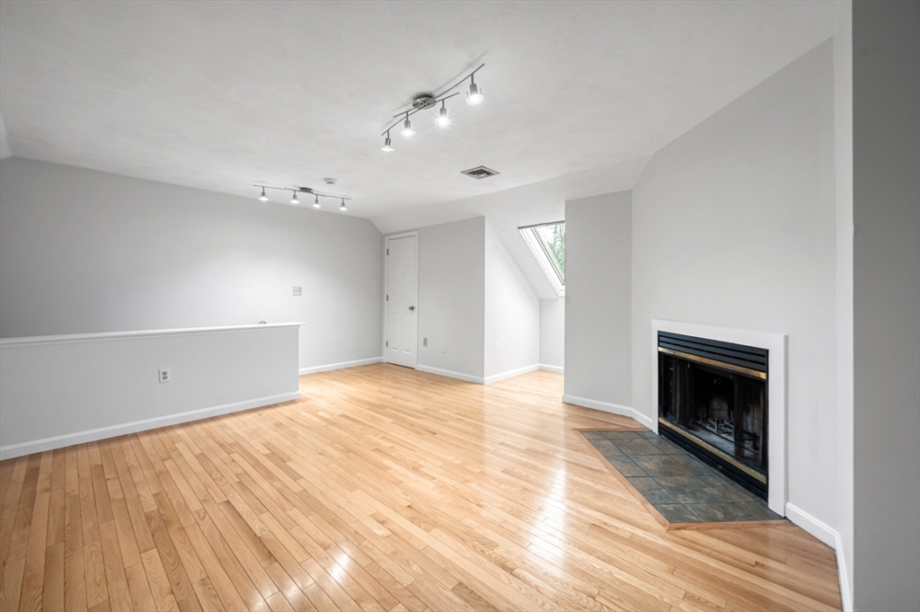4 Deer Path, Unit 3 Maynard, MA 01754 - Photo 23 of 27 a view of an empty room with wooden floor fireplace and a window