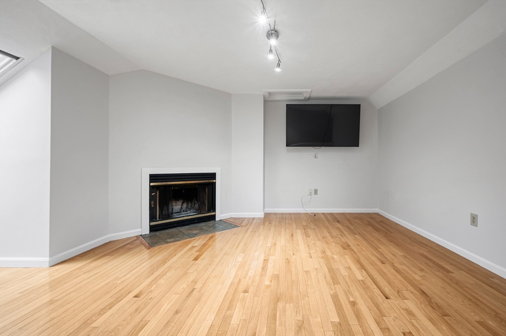 4 Deer Path, Unit 3 Maynard, MA 01754 - Photo 25 of 27 a view of empty room with wooden floor and fireplace