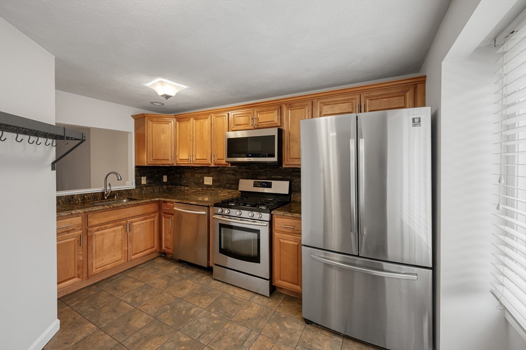 4 Deer Path, Unit 3 Maynard, MA 01754 - Photo 4 of 27 a kitchen with stainless steel appliances granite countertop a refrigerator oven a sink dishwasher and a refrigerator