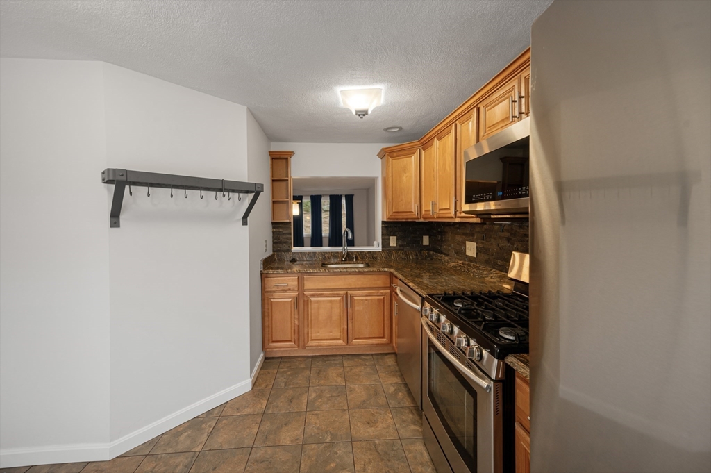 4 Deer Path, Unit 3 Maynard, MA 01754 - Photo 5 of 27 a kitchen with stainless steel appliances granite countertop a stove a sink and a refrigerator