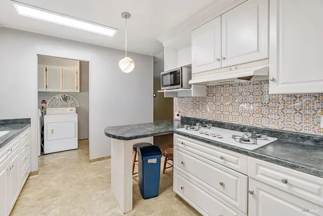 a kitchen with granite countertop a sink stove and cabinets