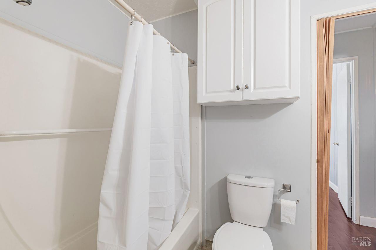 56 Club View Drive Novato, CA 94949 - Photo 8 of 27 a white toilet sitting next to a shower curtain