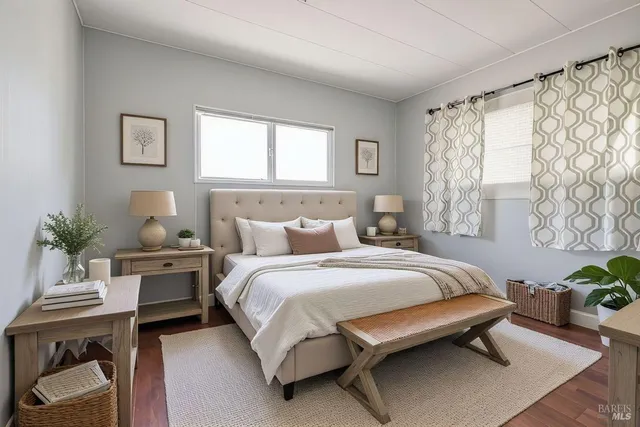 a bedroom with a bed table chair and a window