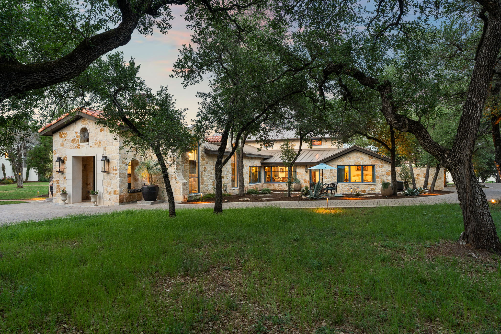 a view of a house with a big yard and large trees