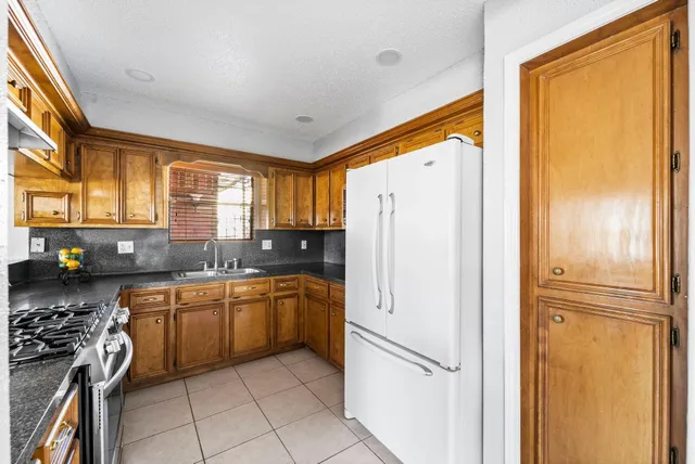 a kitchen with stainless steel appliances granite countertop a stove a sink and a refrigerator