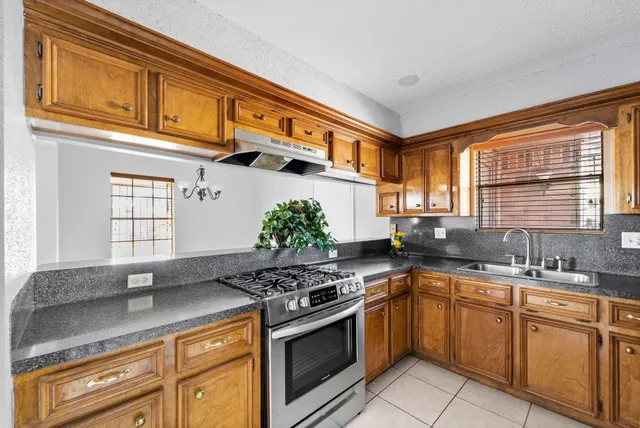 a kitchen with stainless steel appliances granite countertop a sink stove and cabinets