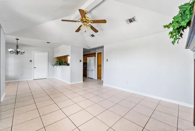 a view of a livingroom with a chandelier fan and wooden floor