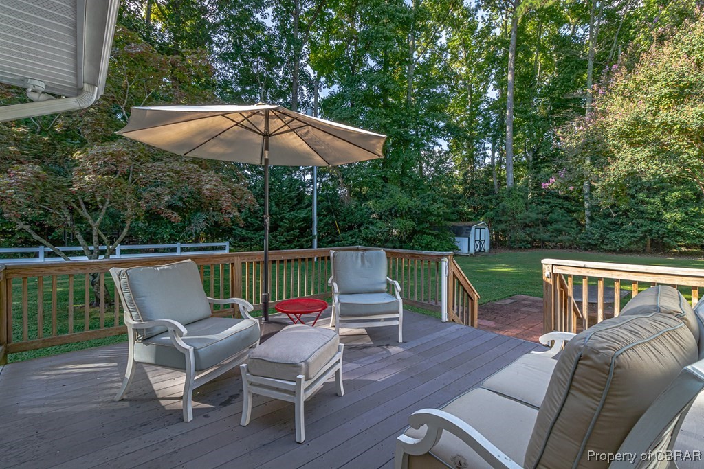35 Powhatan Road Kilmarnock, VA 22482 - Photo 38 of 42 Deck with a storage unit, a lawn, an outdoor hangout area, and an outdoor structure