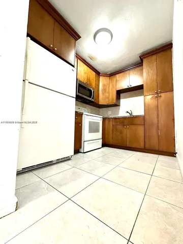 a view of an empty room with a kitchen