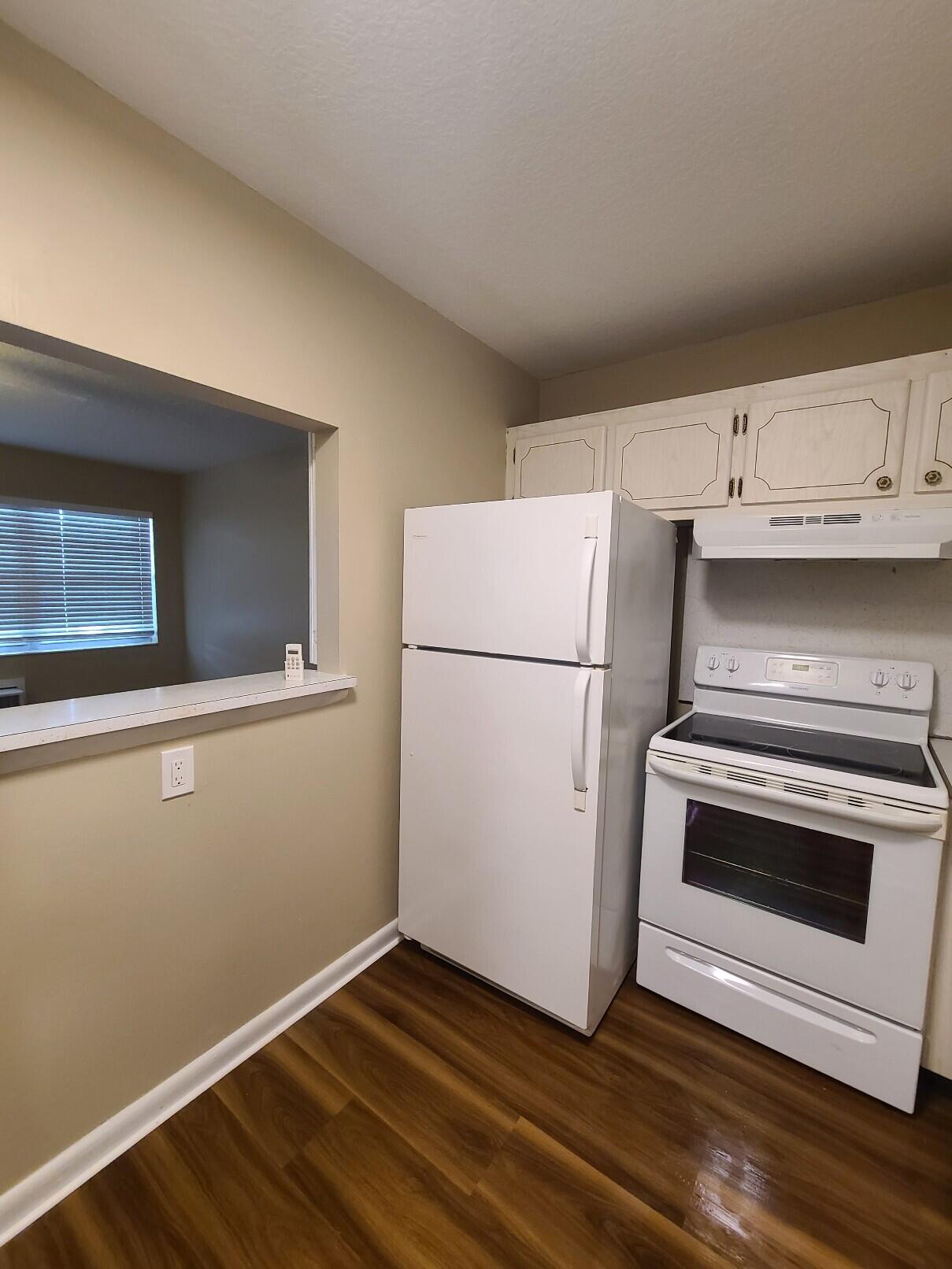 82 Canterbury D, Unit 82 West Palm Beach, FL 33417 - Photo 5 of 13 a kitchen with a refrigerator and a stove