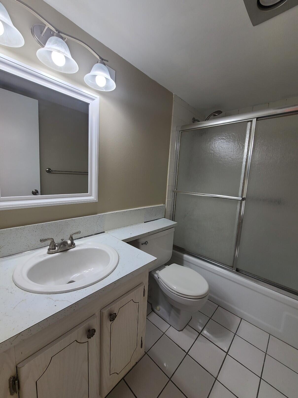 82 Canterbury D, Unit 82 West Palm Beach, FL 33417 - Photo 8 of 13 a bathroom with a sink a toilet and mirror