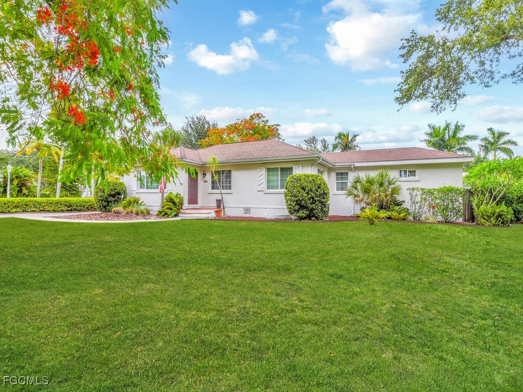 1803 Ardmore Road Fort Myers, FL 33901 - Photo 2 of 39 a view of a white house with a big yard and large trees