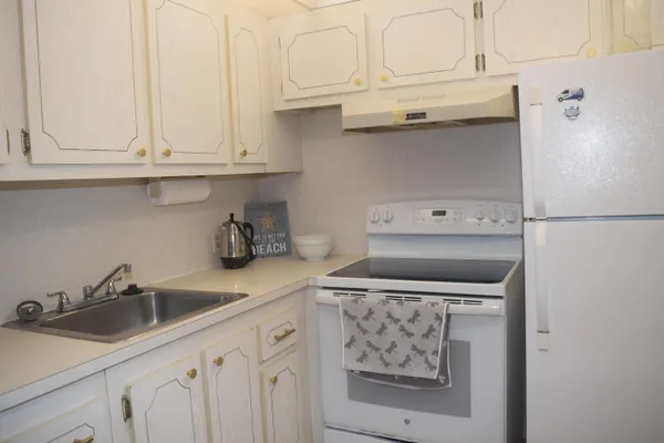 a kitchen with white cabinets and sink