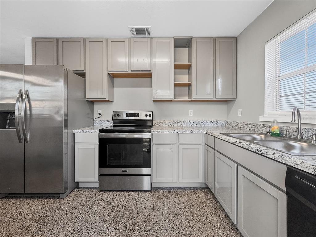 510 North Barrow Avenue Tavares, FL 32778 - Photo 11 of 33 a kitchen with cabinets and stainless steel appliances
