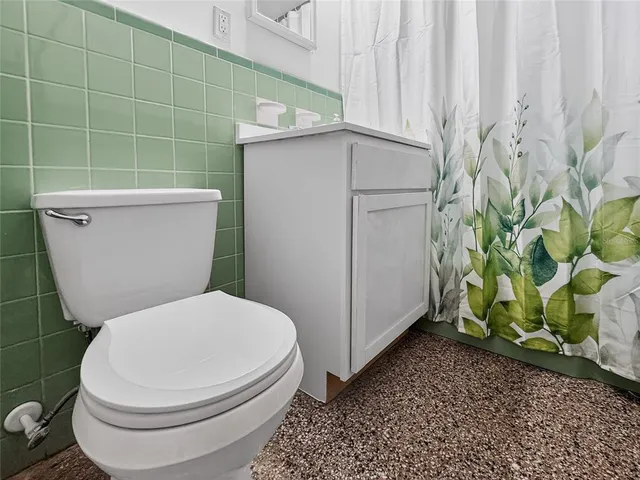 a white toilet sitting next to a shower curtain