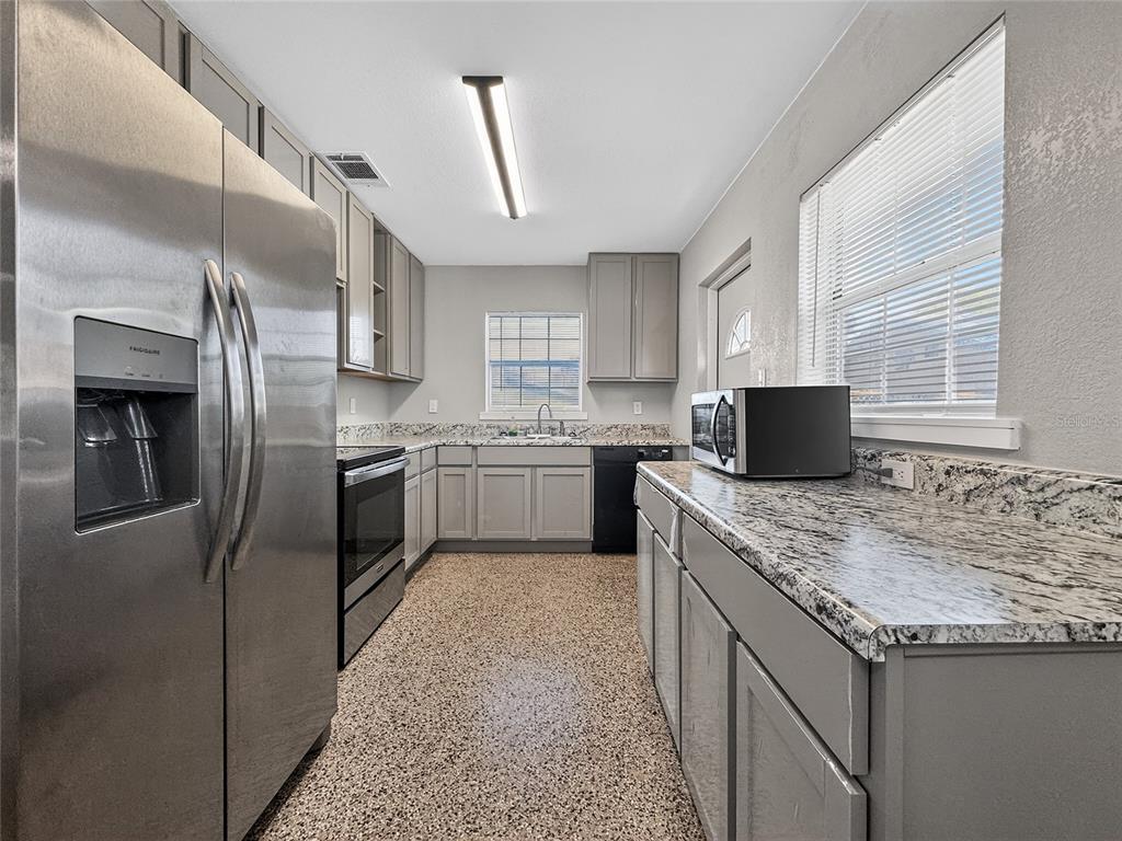 510 North Barrow Avenue Tavares, FL 32778 - Photo 10 of 33 a kitchen with granite countertop a sink stove and refrigerator