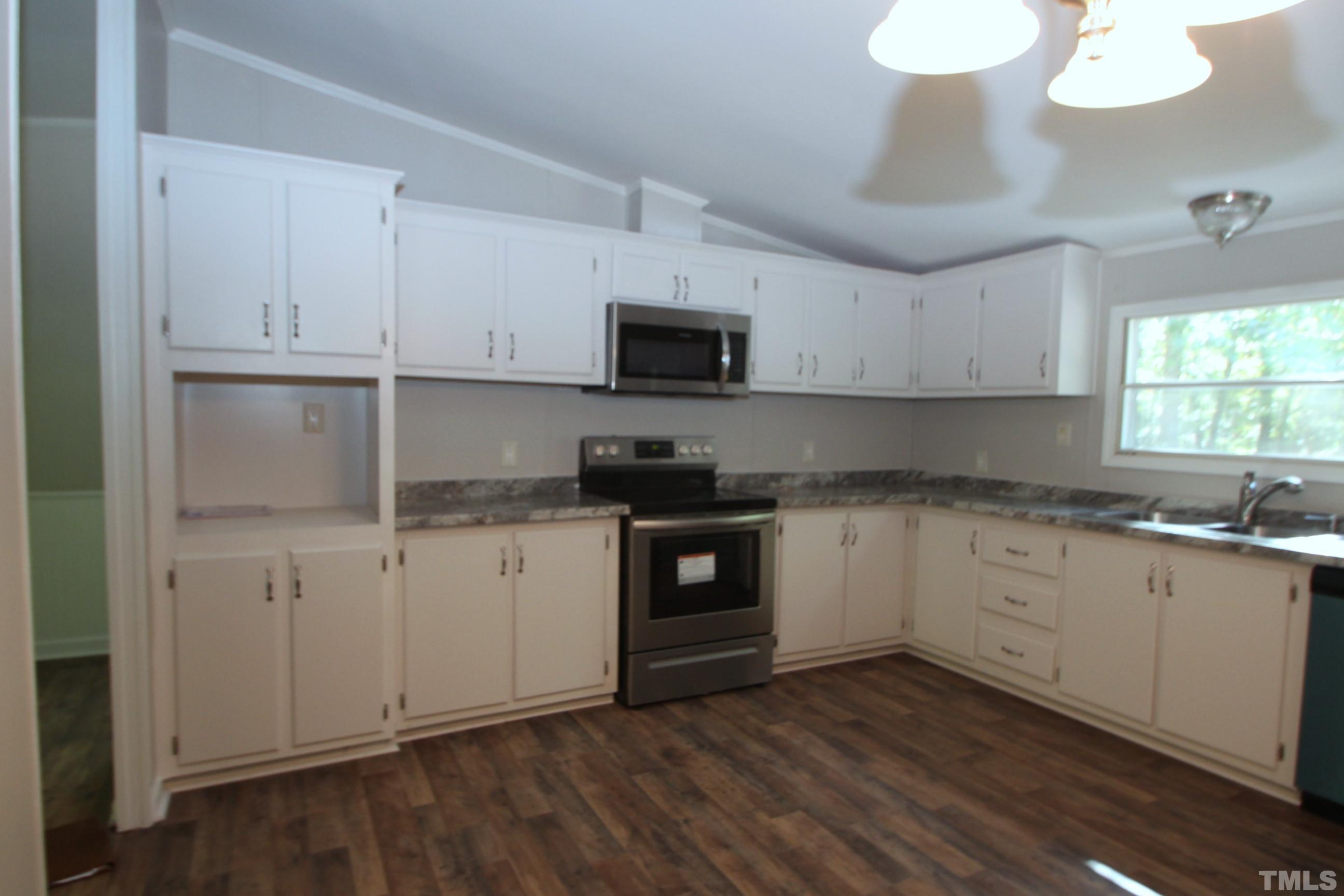 1075 Stoney Mountain Road Rougemont, NC 27572 - Photo 2 of 14 a kitchen with granite countertop white cabinets and white appliances