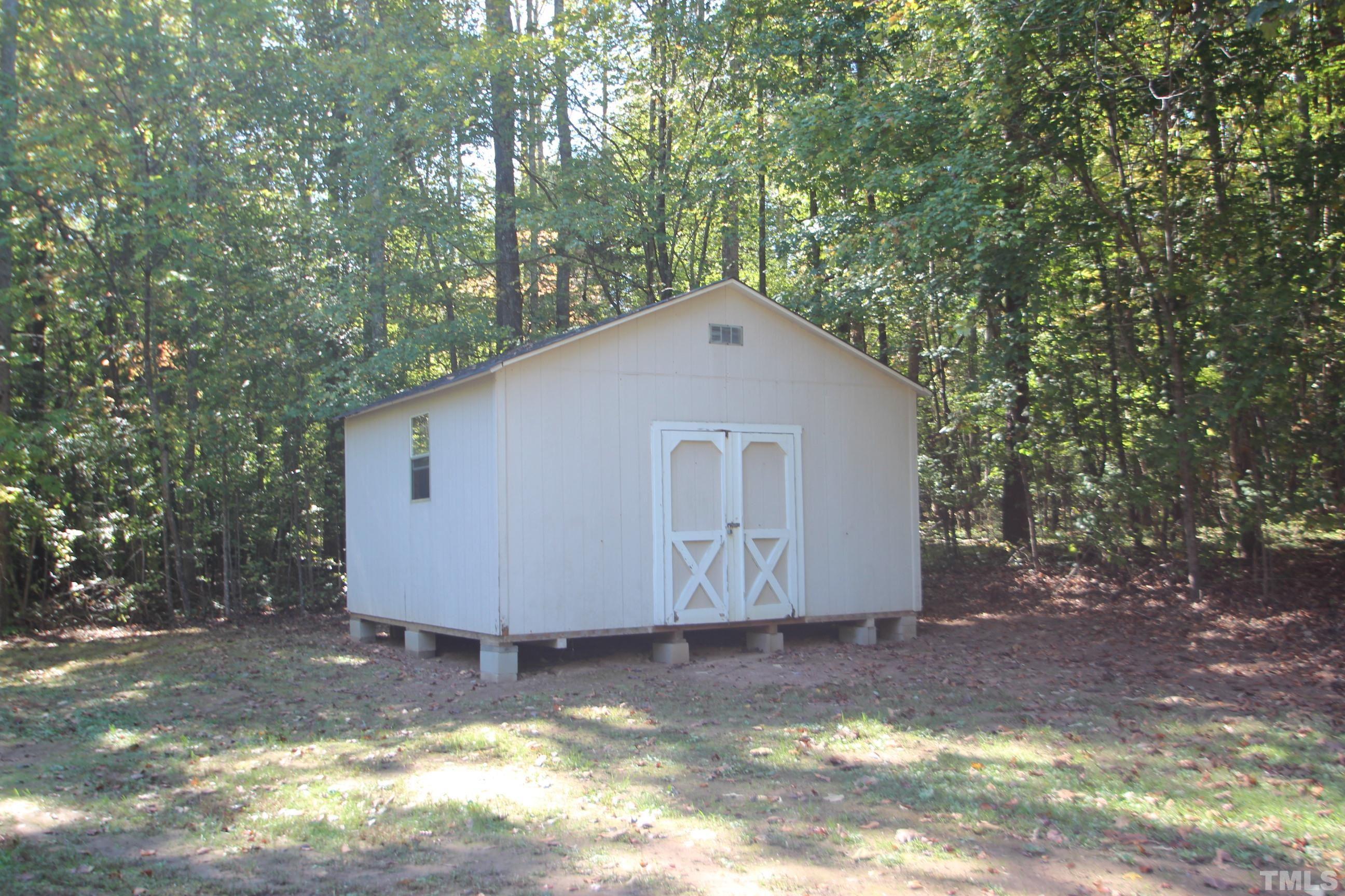 1075 Stoney Mountain Road Rougemont, NC 27572 - Photo 13 of 14 a view of a small yard with large tree and wooden fence