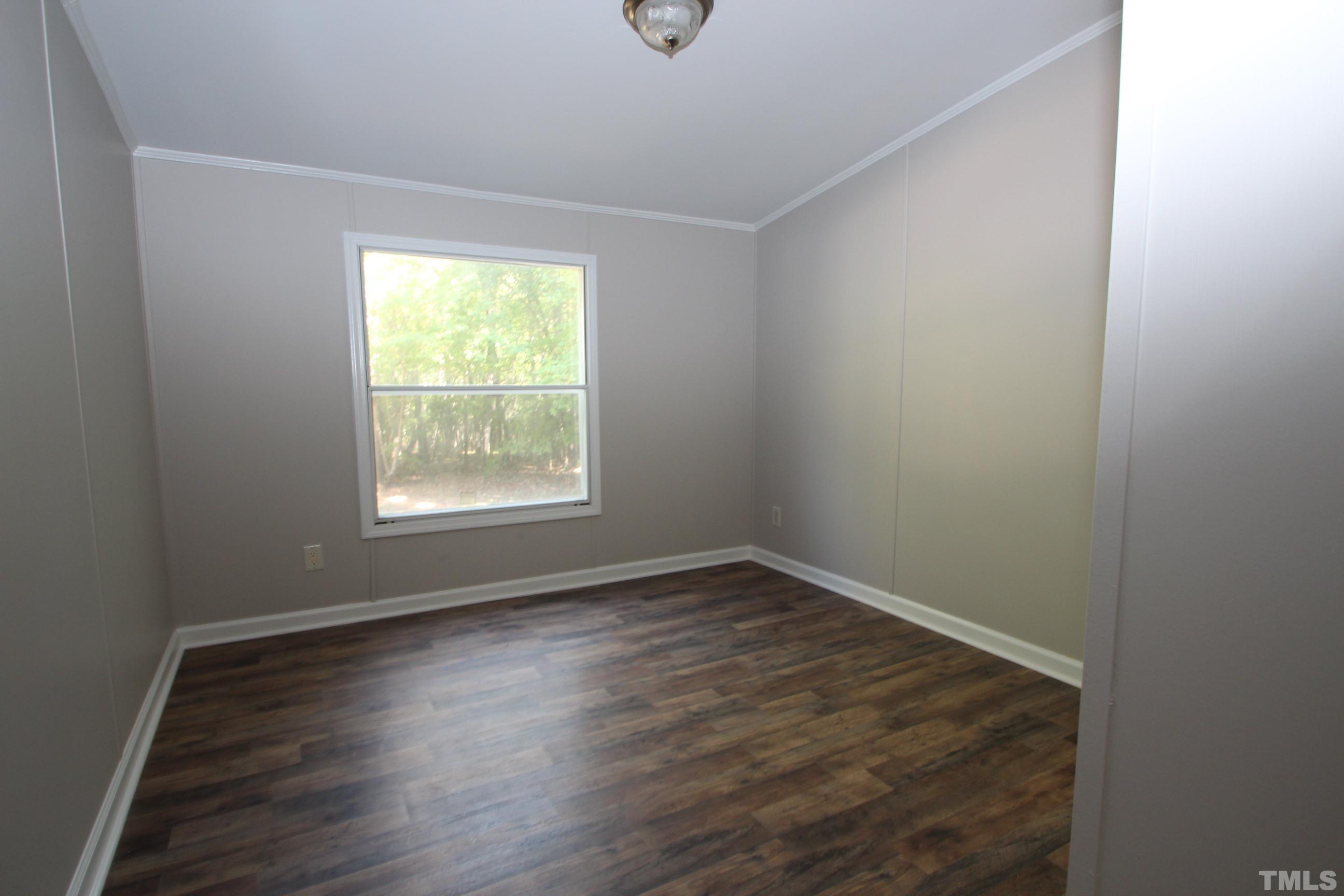 1075 Stoney Mountain Road Rougemont, NC 27572 - Photo 8 of 14 a view of an empty room with wooden floor and a window