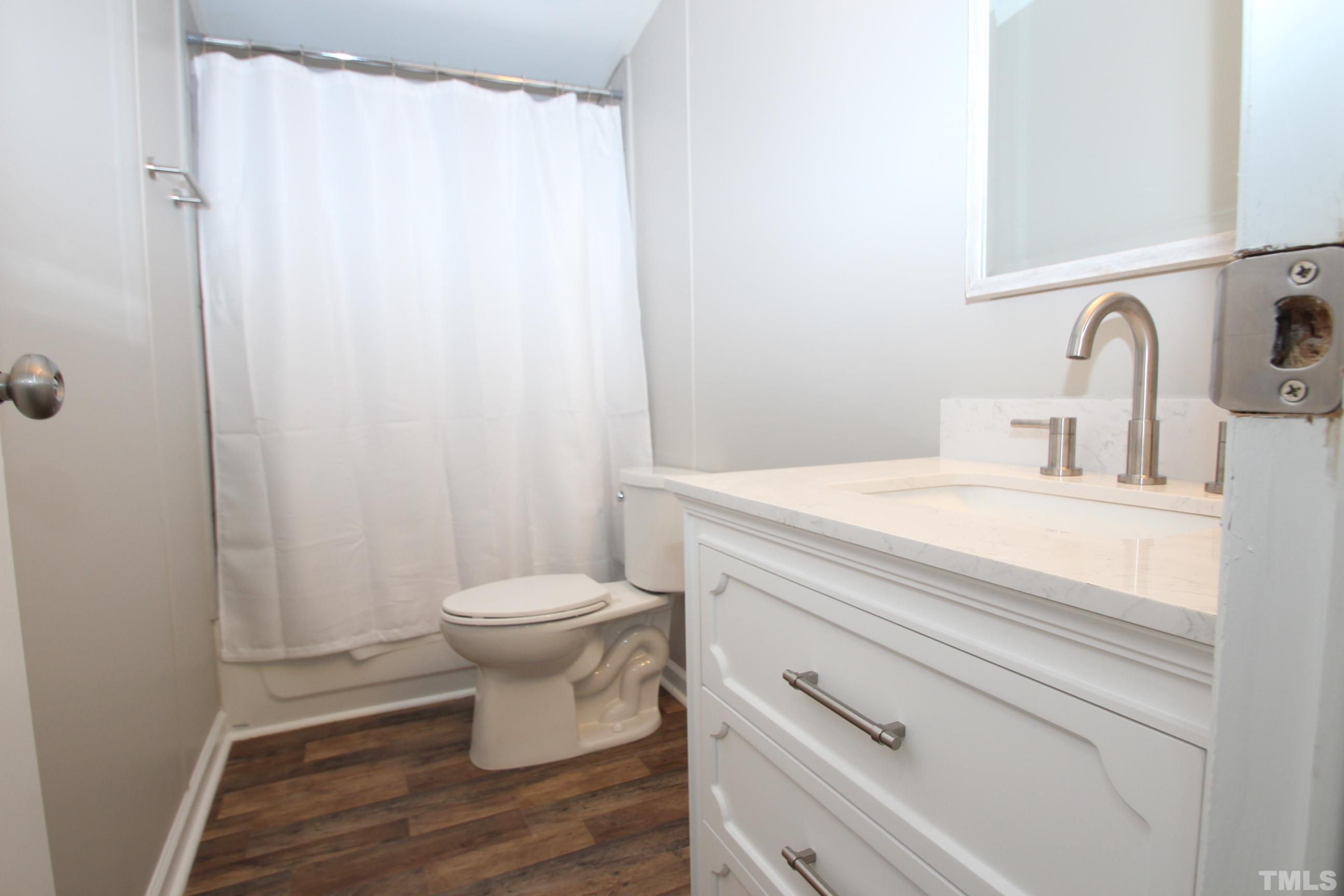 1075 Stoney Mountain Road Rougemont, NC 27572 - Photo 10 of 14 a bathroom with a sink a toilet and shower curtain