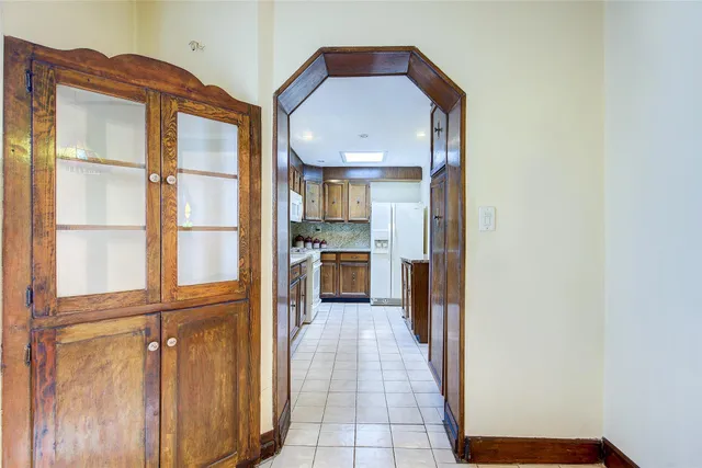 a view of a hallway with wooden floor and a cabinet