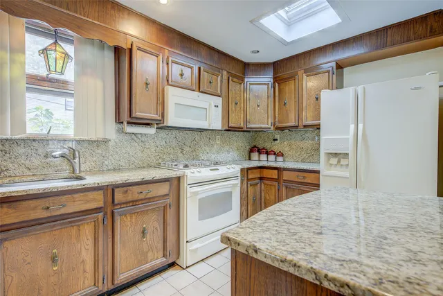 a kitchen with cabinets appliances a sink and a counter top space