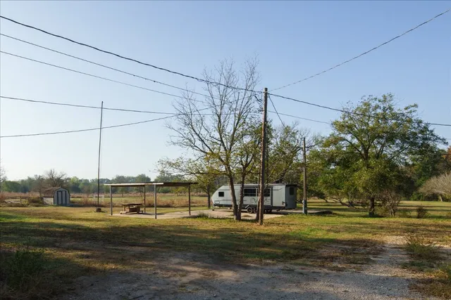 a view of a big house with a big yard and large trees